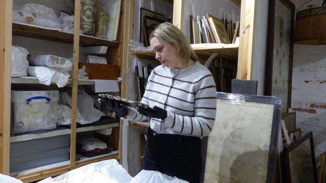 Emily Greaves, Collections and House Manager at Packwood House, inspects the Mills Salver in the storeroom at Baddesley Clinton, Warwickshire